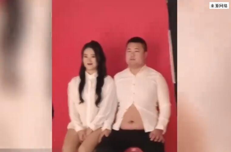 男子穿“露脐衫”拍结婚证登记照 女子在努力憋笑
